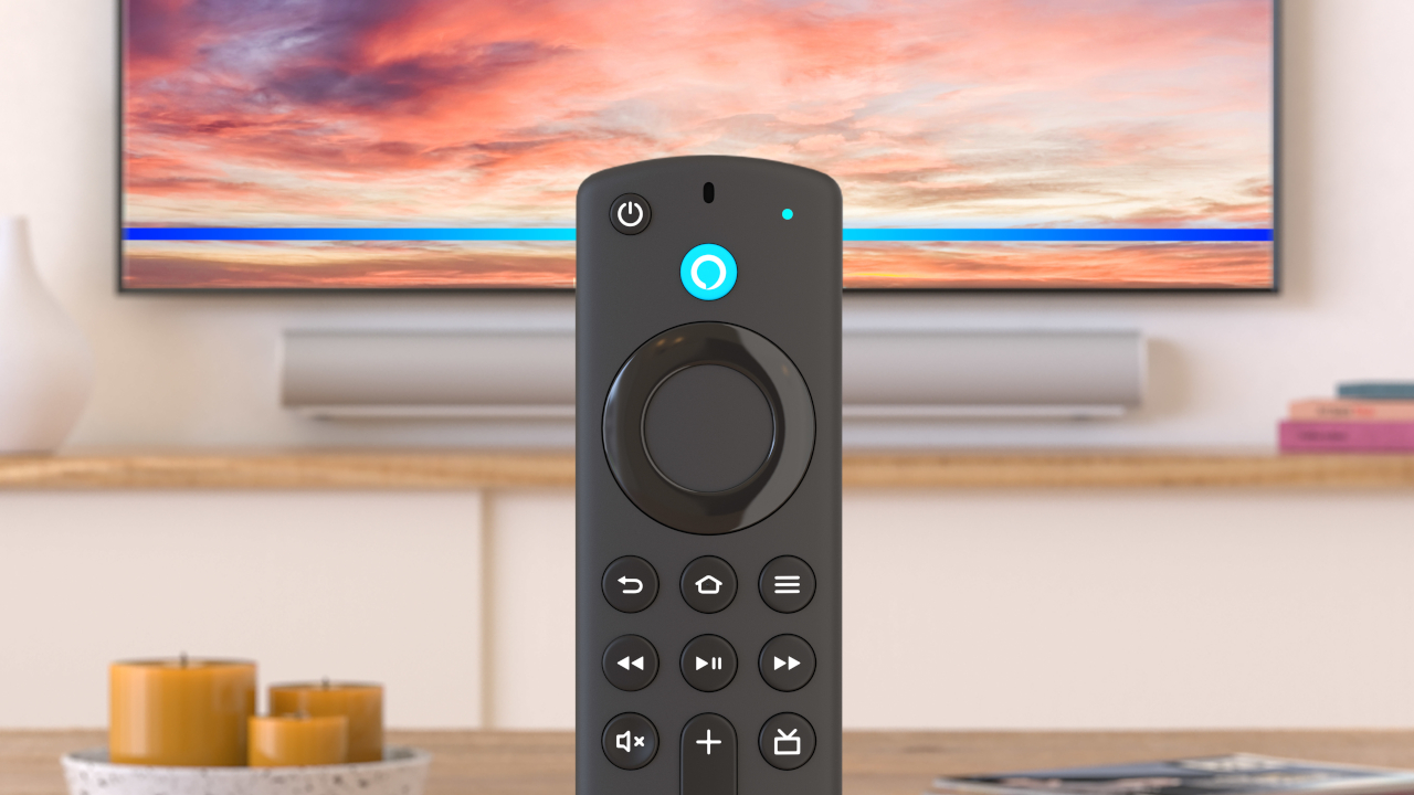 Il telecomando di Fire TV, con sullo sfondo la parte bassa di un televisore e una soundbar