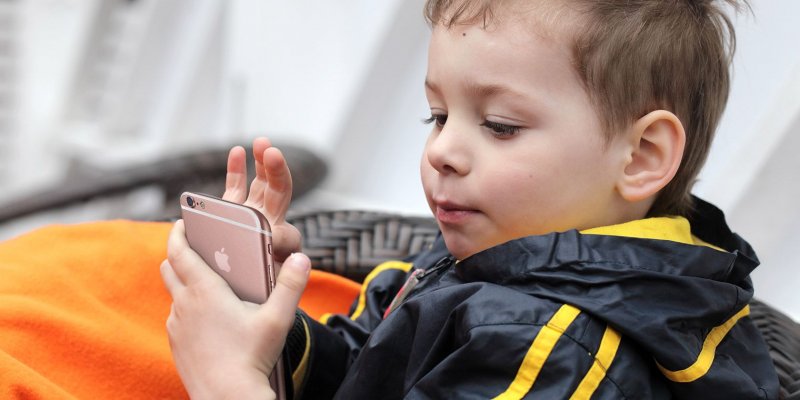 Un bambino che utilizza iPhone 6s Un bambino che utilizza iPhone 6s