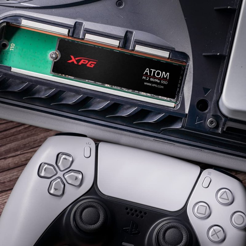 SSD Adata dentro una PS5, con controller DualSense in basso