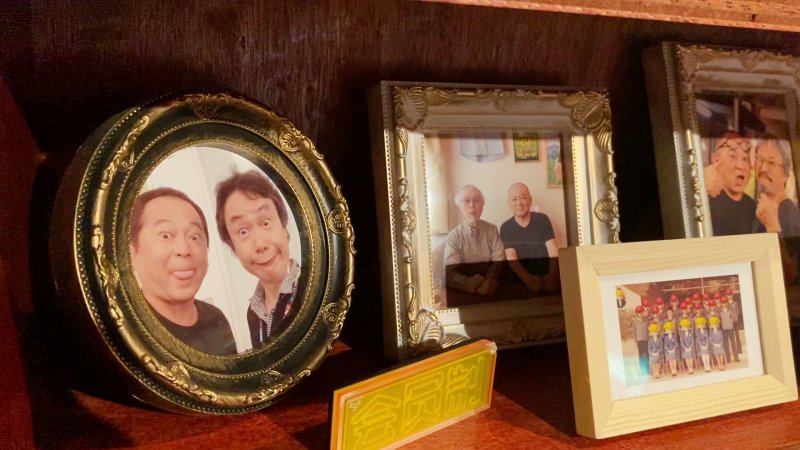 Su un mobile del bar ci sono le vecchie foto di Chokan con ex colleghi e amici