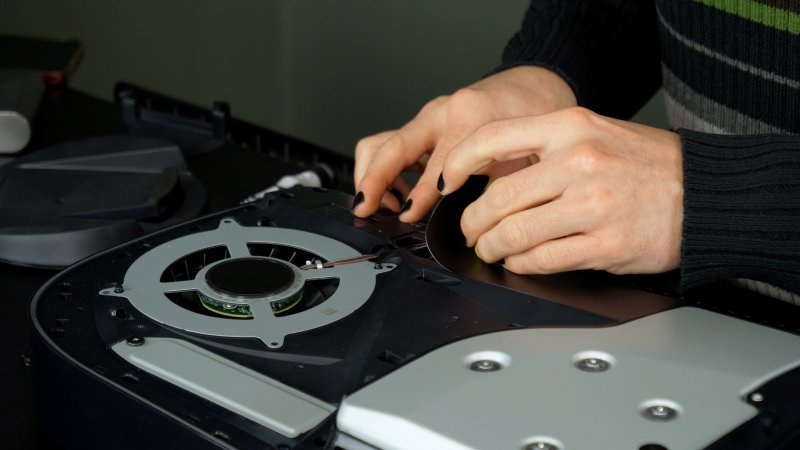 Per rimuovere la ventola di PS5 è sufficiente sollevare il pannello nero di plastica in questo modo