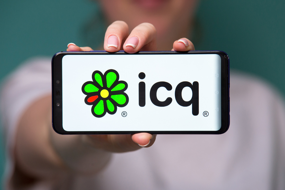 Il logo di ICQ sullo schermo di uno smartphone tenuto in mano da una persona