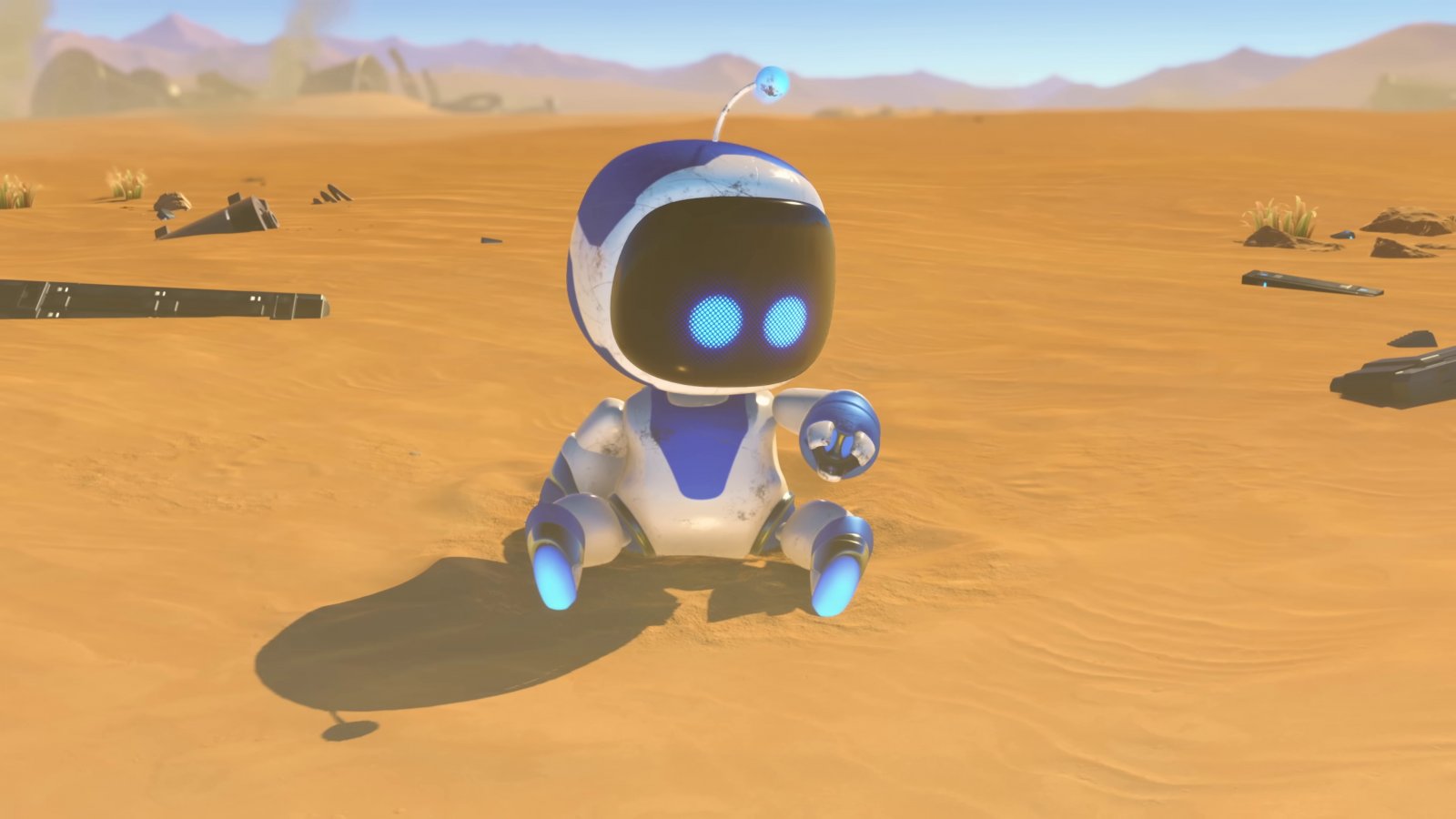 Astro Bot seduto in mezzo alla sabbia mentre si guarda il braccio sinistro