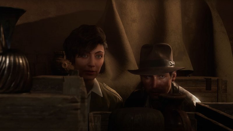 Gina e Indiana nascosti dietro ad alcune casse in Indiana Jones e l'Antico Cerchio
