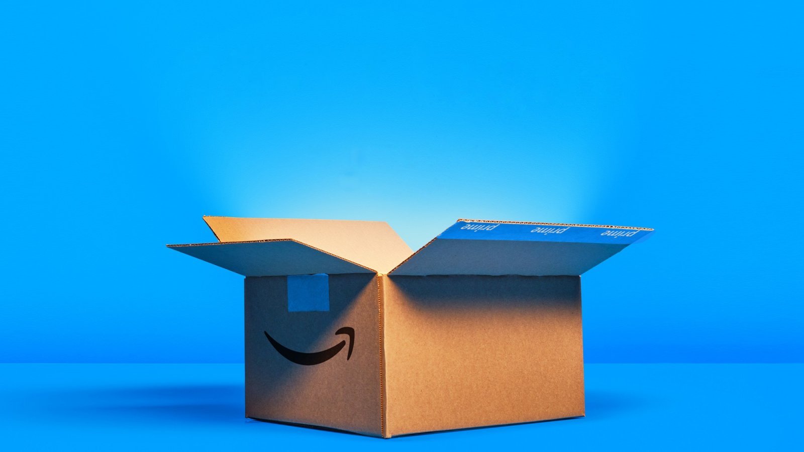 Una scatola di Amazon aperta con sfondo azzurro
