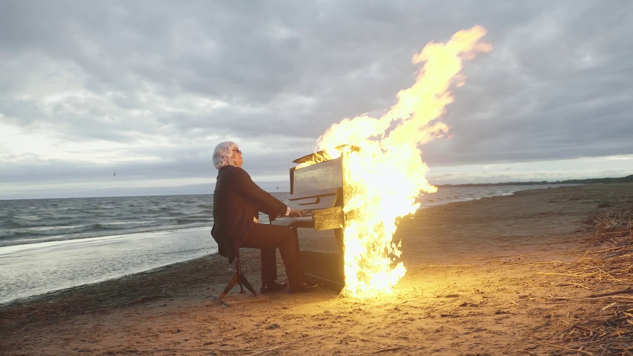 Compositore che suona su un pianoforte che va a fuoco