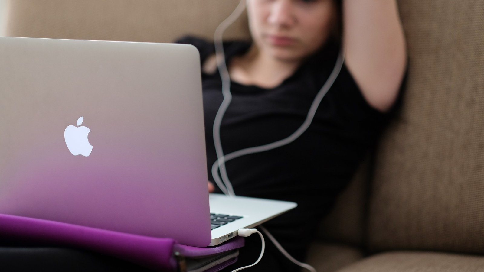 Una ragazza che ascolta un podcast su un MacBook