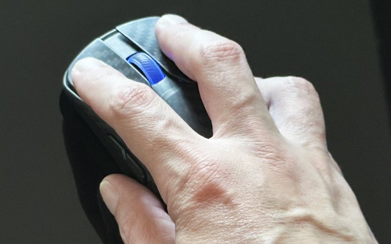 L'ASUS ROG Harpe Ace Extreme impugnato e con l'illuminazione accesa sullo scroller L'ASUS ROG Harpe Ace Extreme impugnato e con l'illuminazione accesa sullo scroller