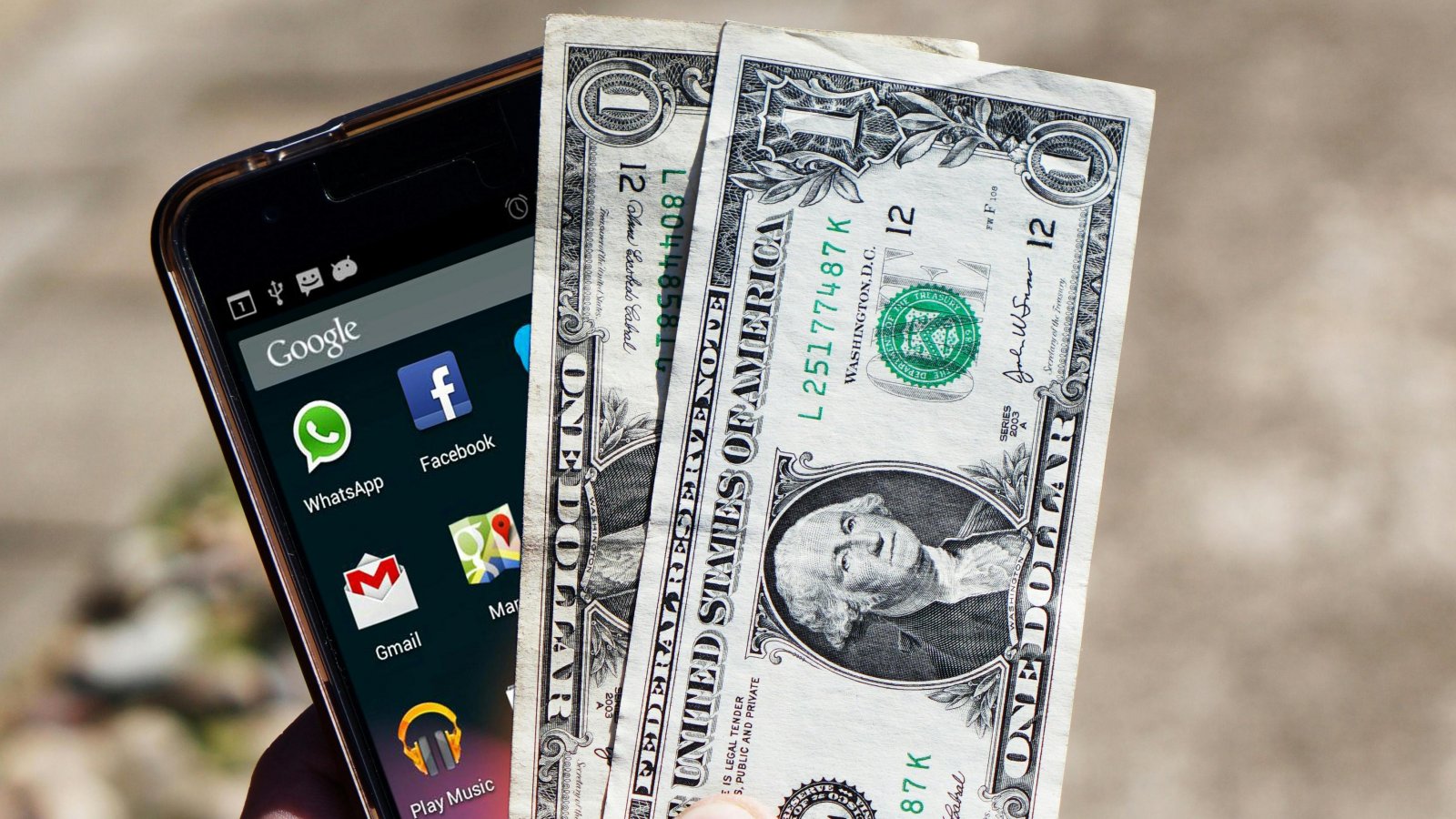 uno smartphone e due banconote da un dollaro