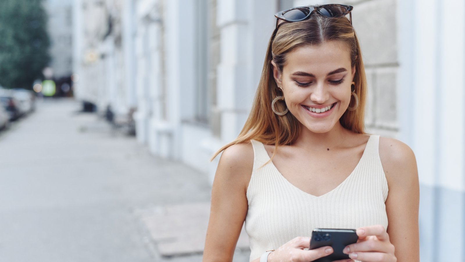 Una ragazza che ride mentre guarda lo smartphone