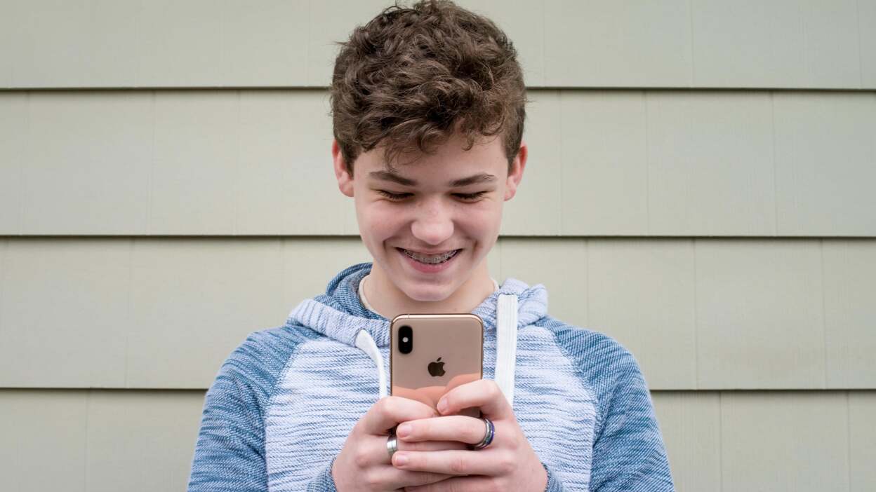 Bambino che manda messaggi con iPhone