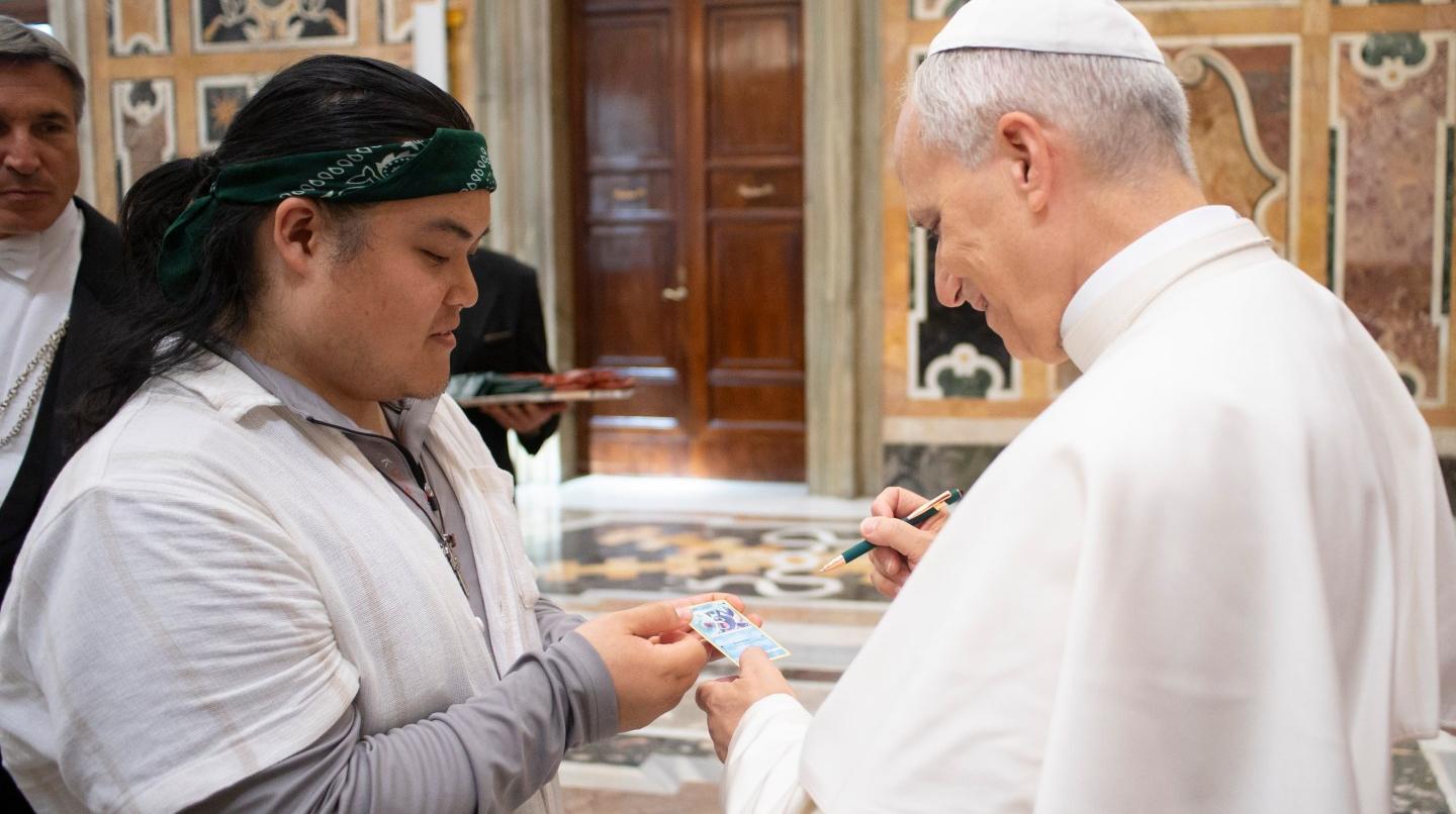 Papa Leone XIV firma una carta Pokémon
