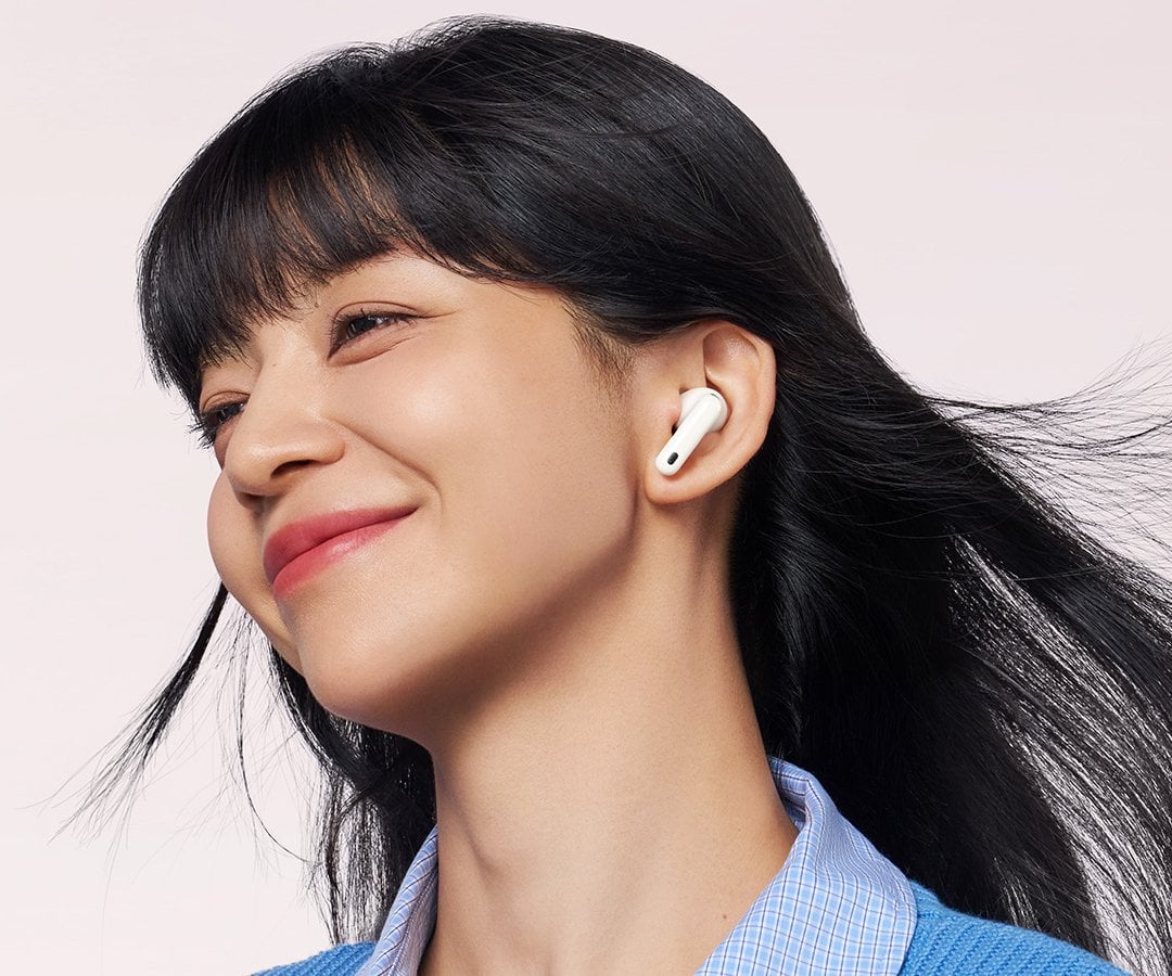 Una modella sorridente indossa le Huawei Freebuds 7i